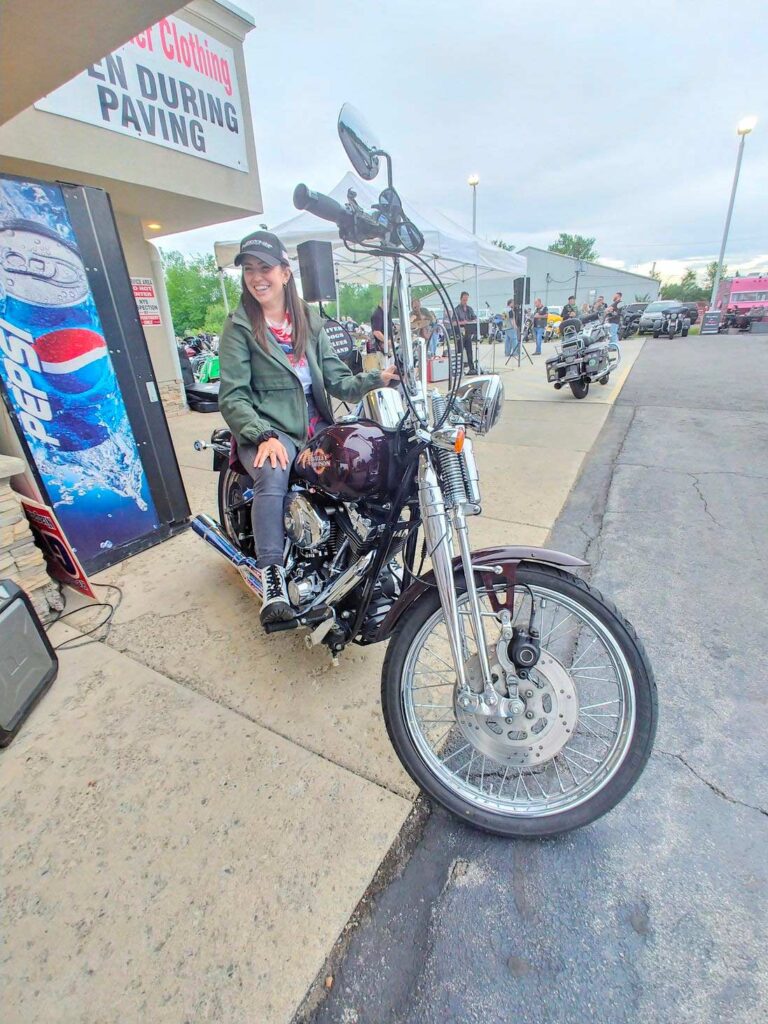 Attorney Christina Gullo sits on a Harley Springer Softail motorcycle